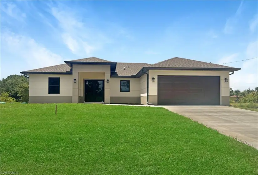 View of front of home featuring a garage and a front lawn