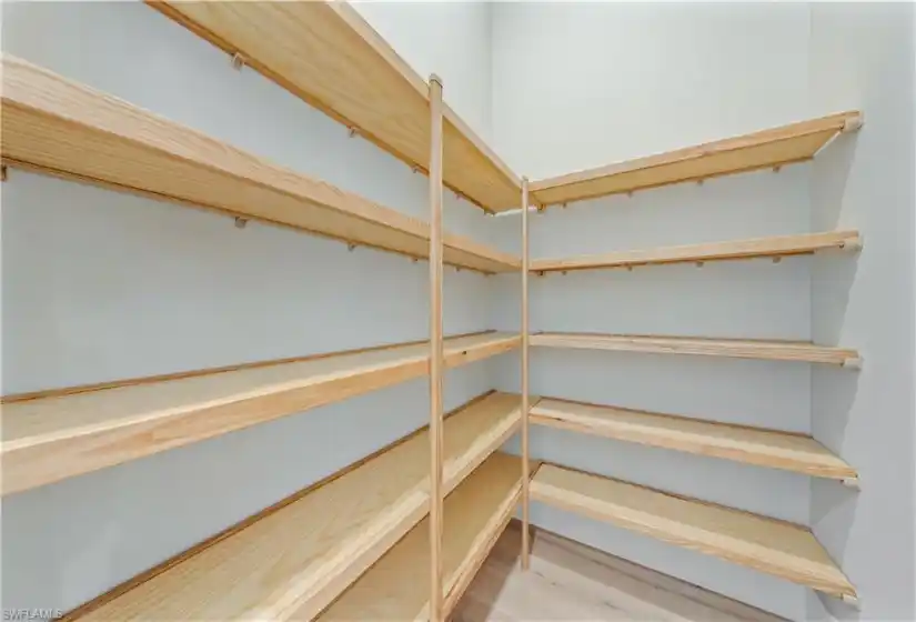 Walk-in pantry with solid copewood shelving.