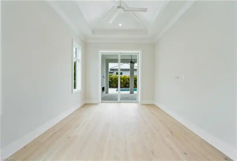 The primary bedroom features a vaulted ceiling with nickel gap treatment and 10' sliders leading out to the pool deck.